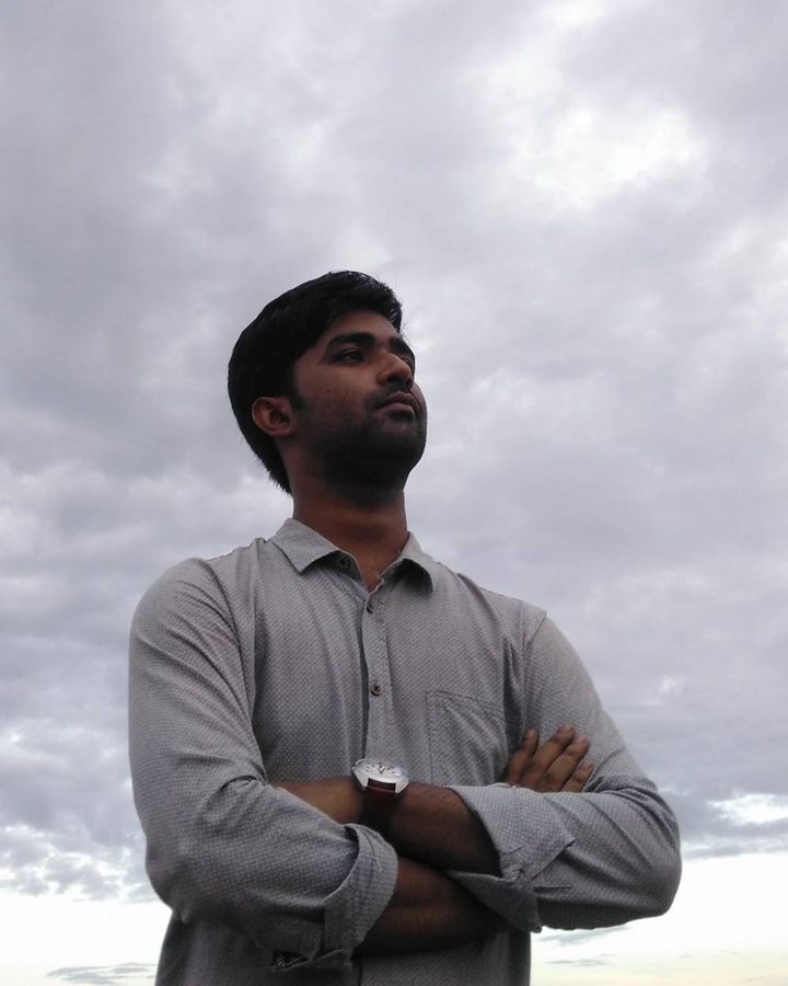 Mehrab Mashrafi standing with arms crossed against a cloudy sky
